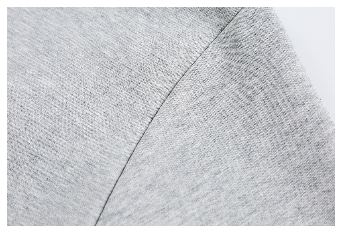 Close-up of light gray knit fabric with a curved seam.