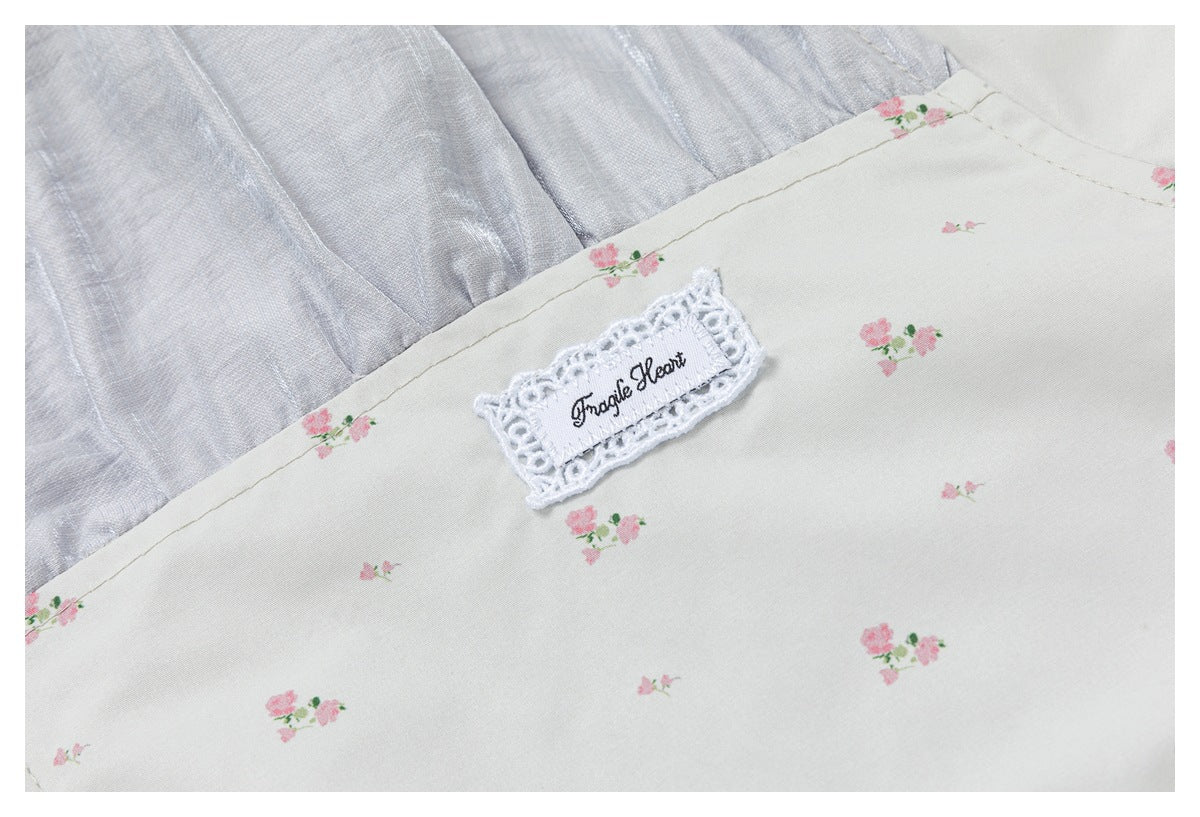 Close-up of pink floral print and a decorative sewn label reading “Imagine Heart.”