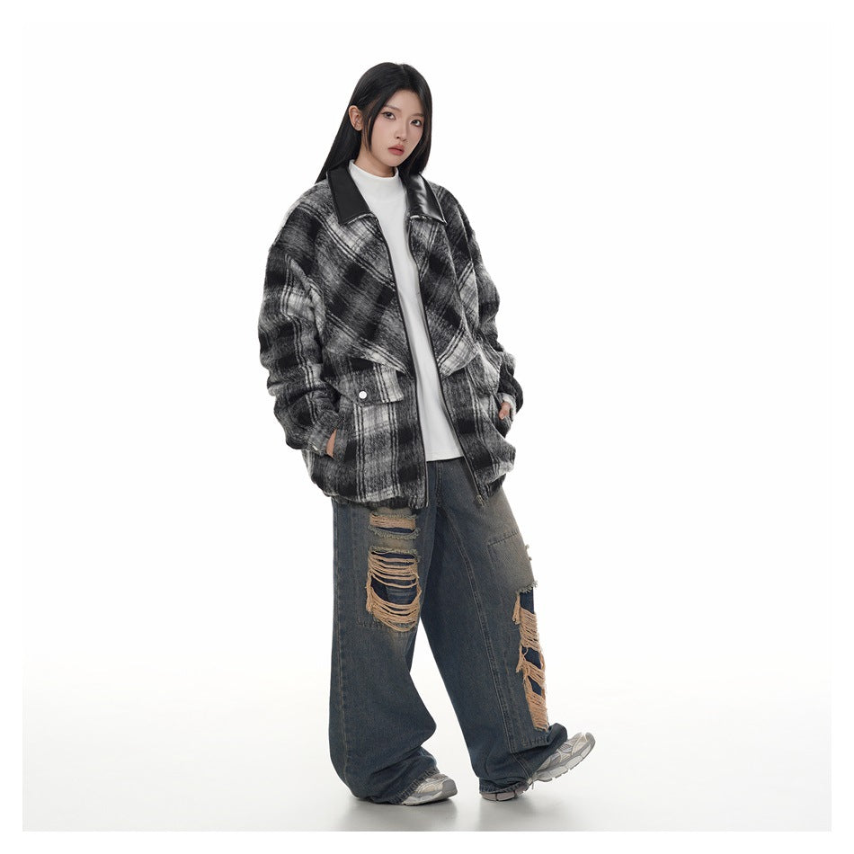 Full-length view of a model in the black plaid oversized zip jacket with white top and distressed wide-leg jeans