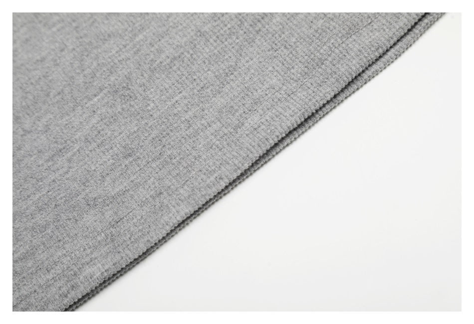 Close-up of the gray knit shirt fabric and finished edge.