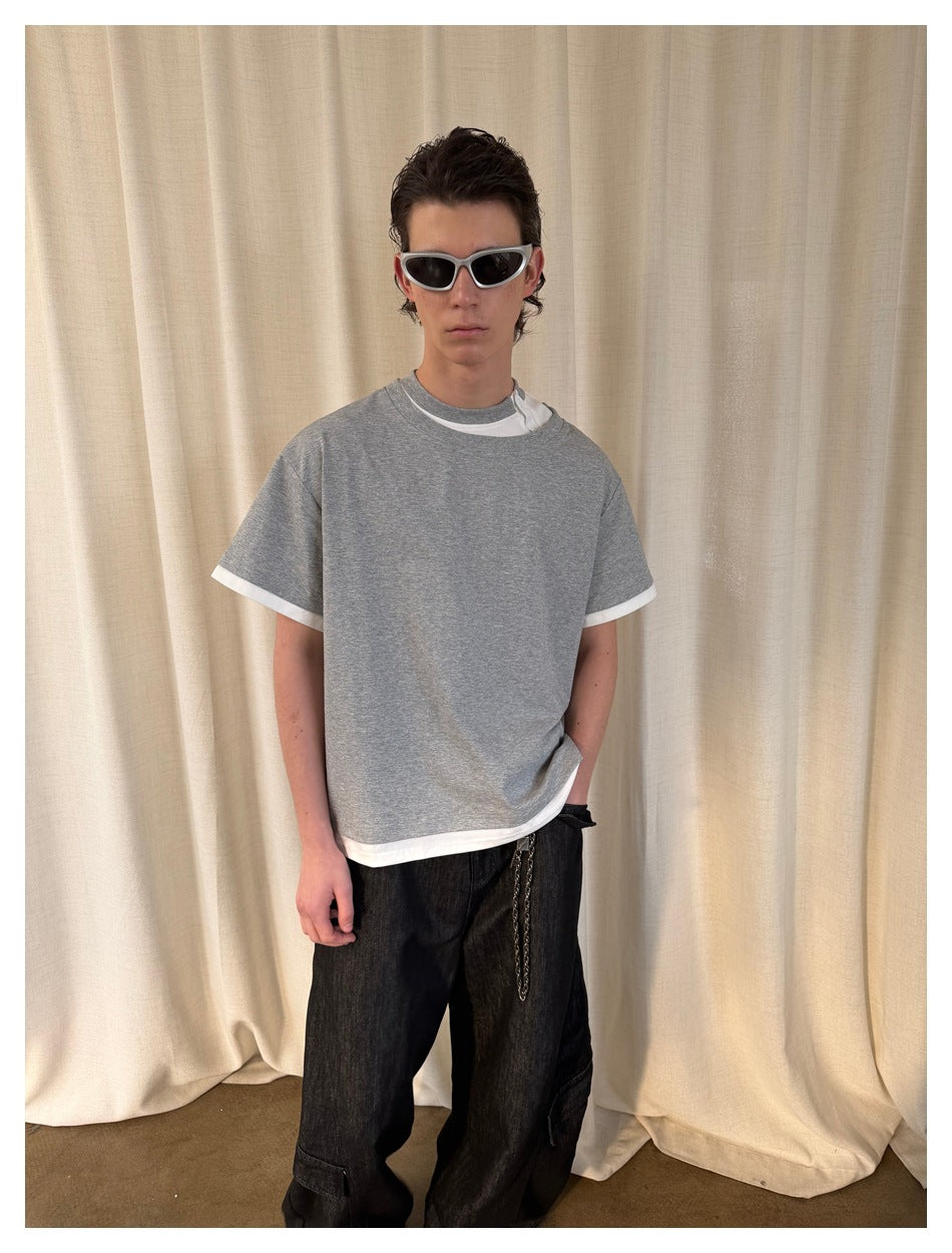 Model wearing a loose heather-gray T-shirt with white layered trim at the collar, sleeves, and hem.