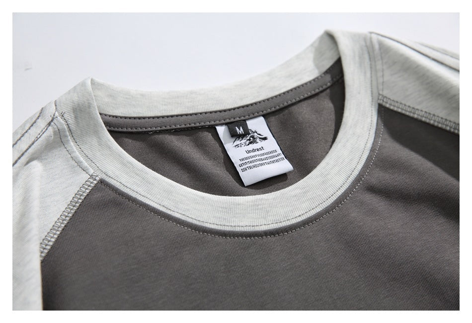 Close-up of the gray crew neck, shoulder seams, and inner garment label.