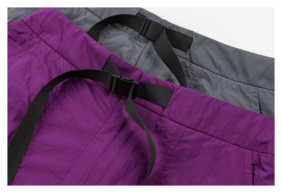 Close-up of purple and gray skirts showing adjustable black webbing waist straps and buckles.