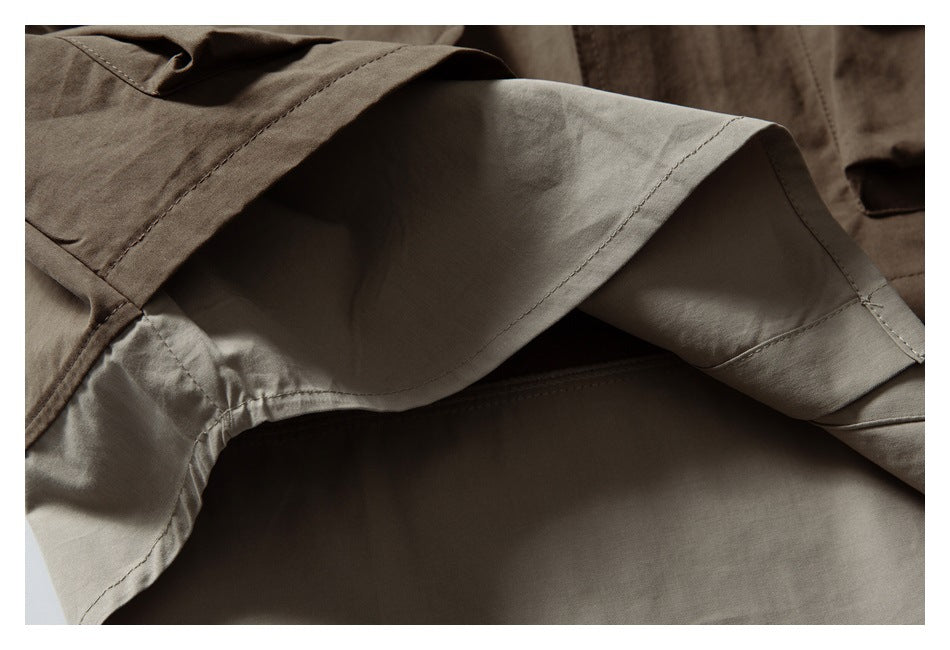 Close-up of layered brown and beige garment fabric, showing folded edges and stitched seams.