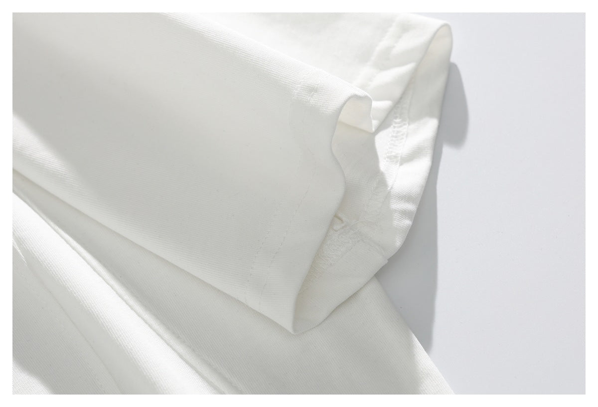 Close-up of a white garment sleeve cuff and stitched seam on a pale background.