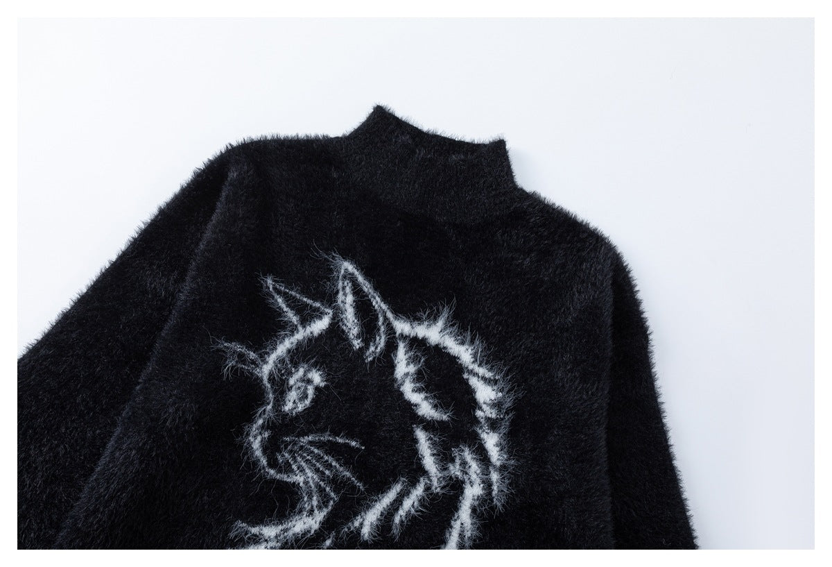 Close-up of a black fuzzy high-neck sweater showing its white cat illustration on the front.