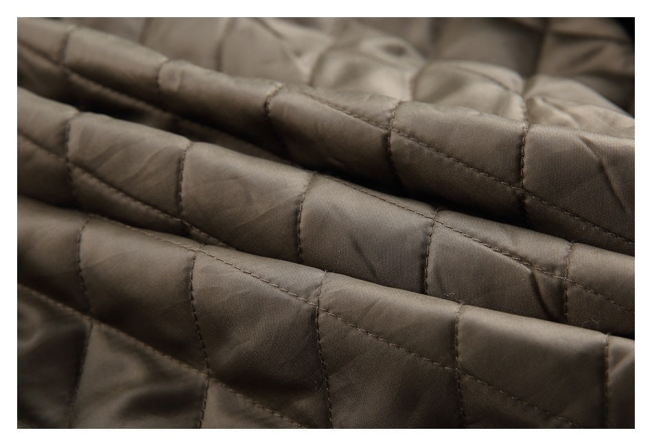 Macro view of taupe-brown quilted fabric, showing padded sections and stitching.