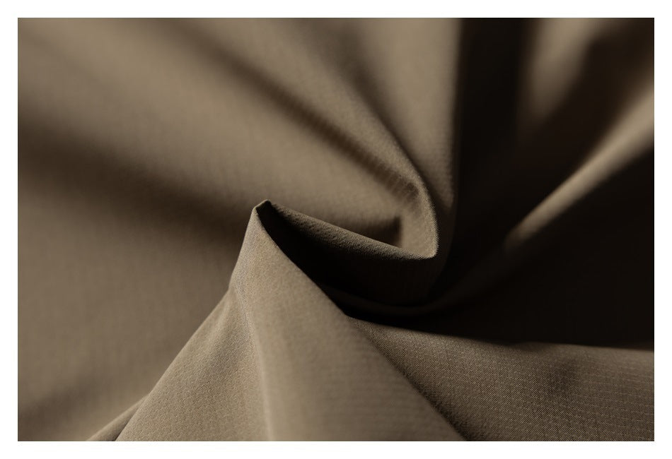 Macro view of softly folded olive-brown garment fabric and its surface texture.