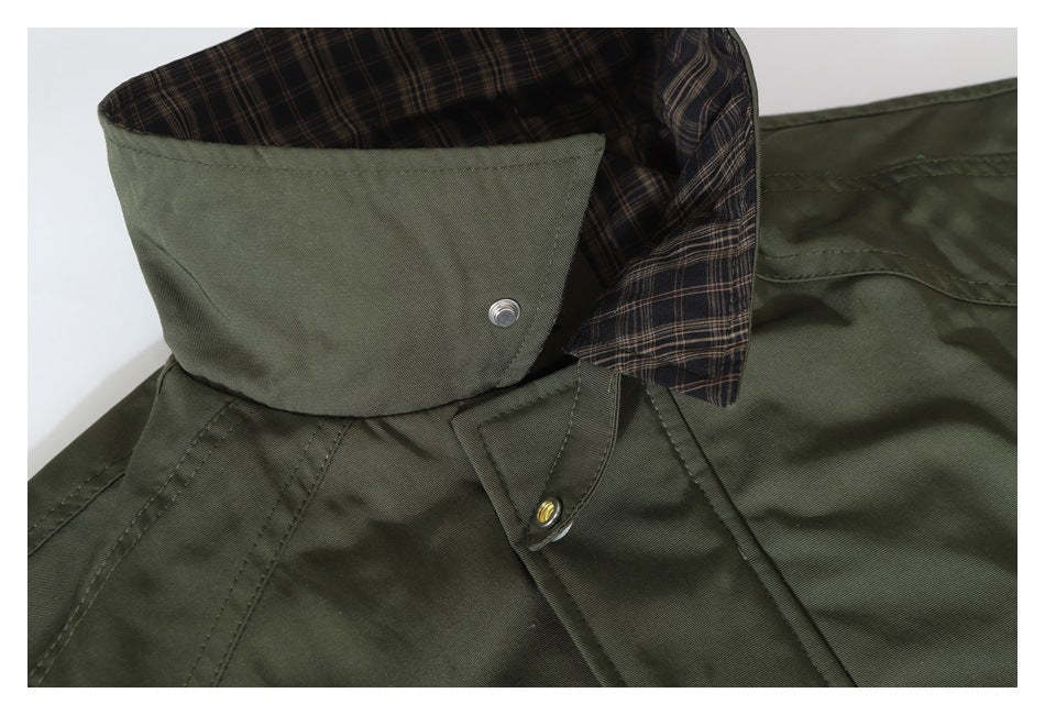 Close-up of an olive jacket's raised collar, plaid lining, and snap-tab fastening.