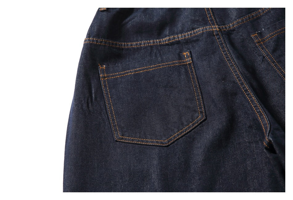 Close-up of a rear pocket and orange stitching on dark indigo jeans.