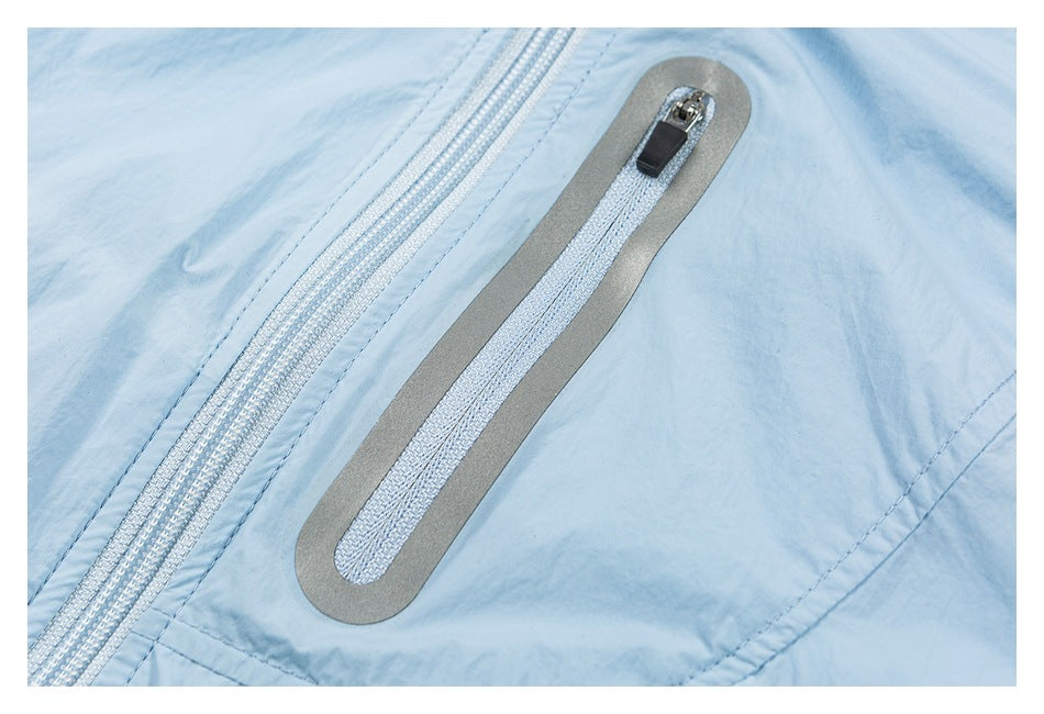Close-up of a light blue garment with a gray-trimmed zipper pocket and a nearby white zipper.