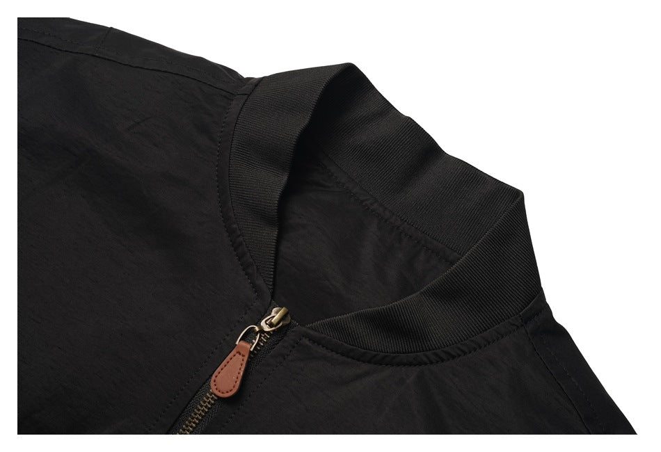 Close-up of the black jacket's ribbed collar and brass-tone zipper with a brown pull tab.