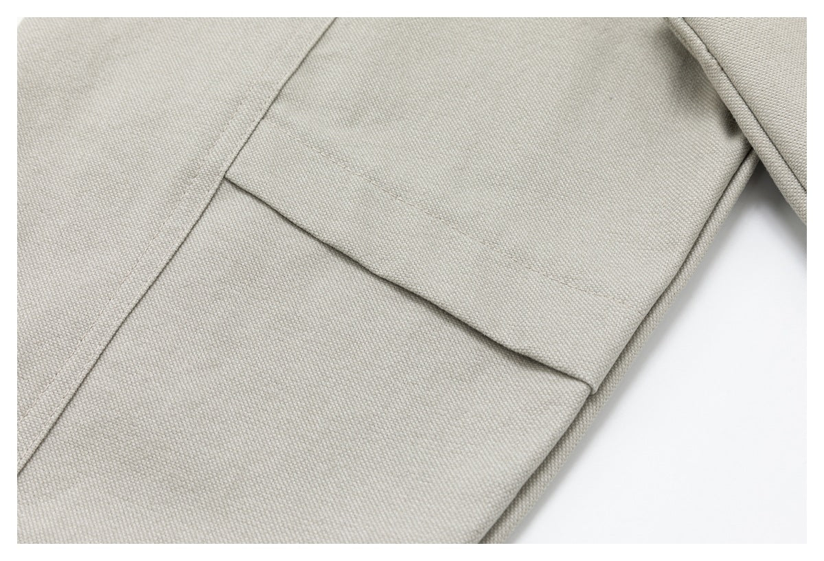Close-up of a flap pocket on the light beige jacket.