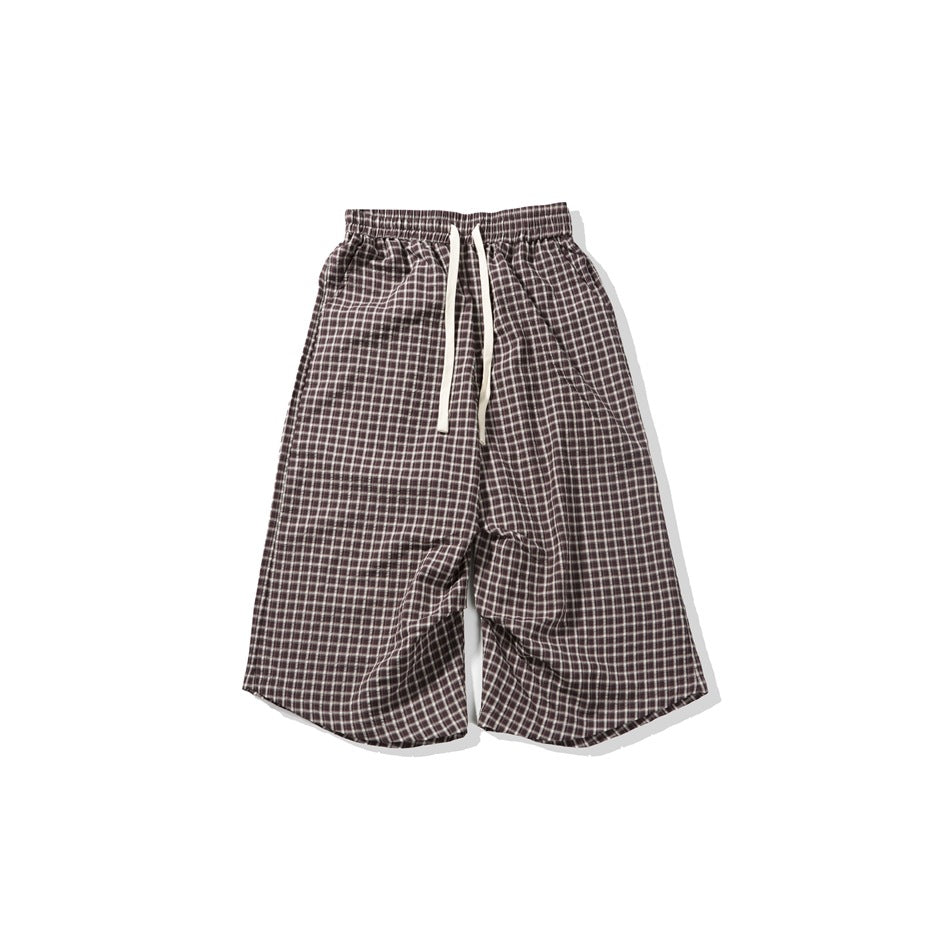 Brown and white plaid drawstring shorts with elastic waist, flat lay, wide legs