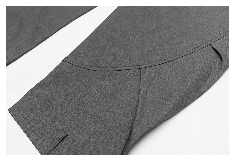 Close-up of gray garment fabric with curved seam details and a small folded edge.