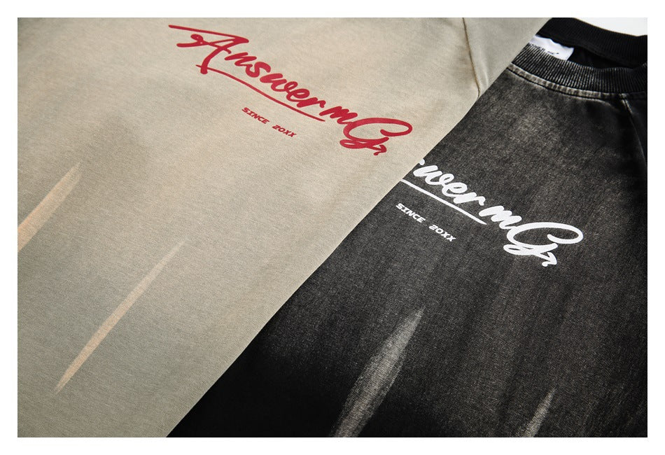 Two crewneck tops in muted khaki and black, each with large contrasting script lettering on the chest.