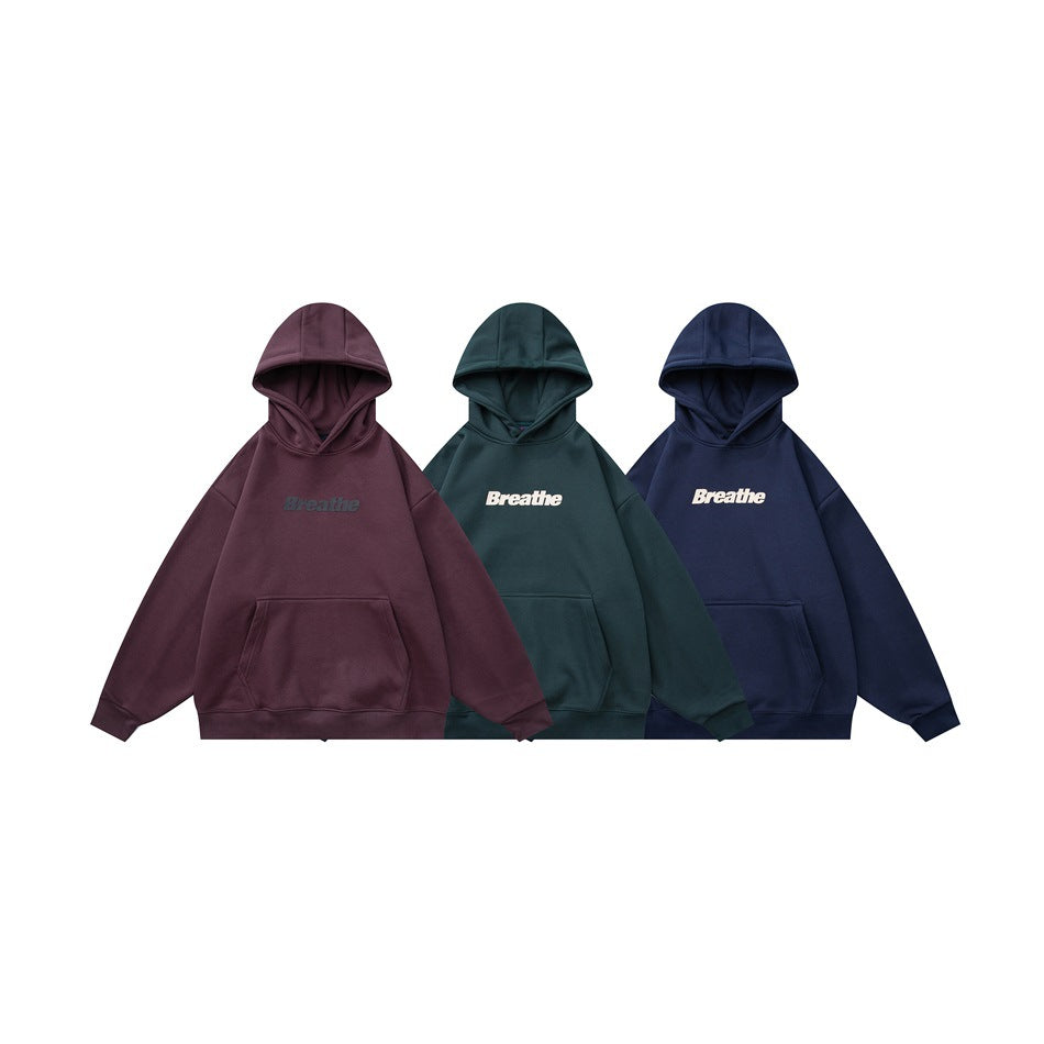 Three front views of pullover hoodies in burgundy, dark green, and navy, each with a kangaroo pocket and “Breathe” print.
