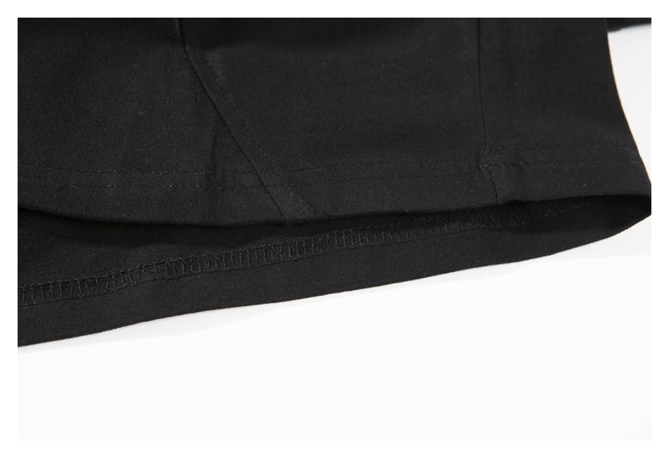Close-up of the black garment's lower hem, showing stitching and the finished inner edge.