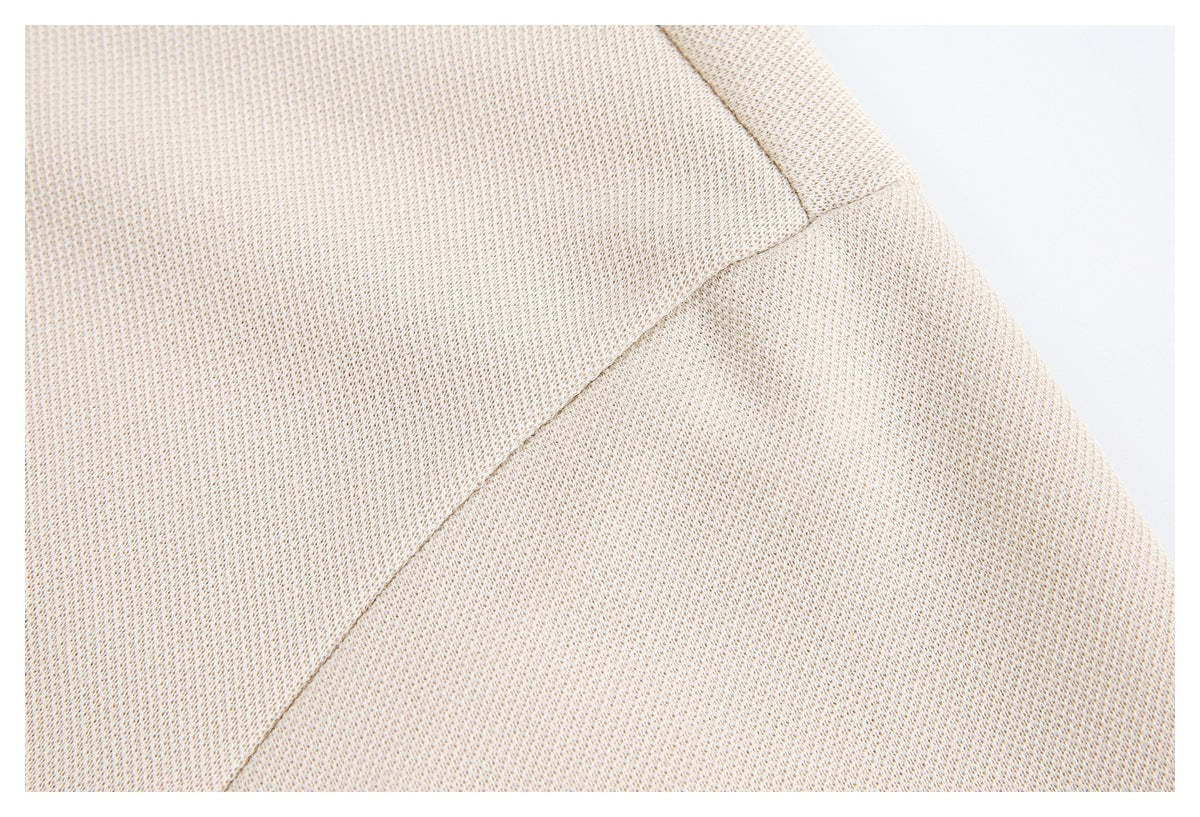 Close-up of cream-beige textured fabric with a diagonal stitched seam.