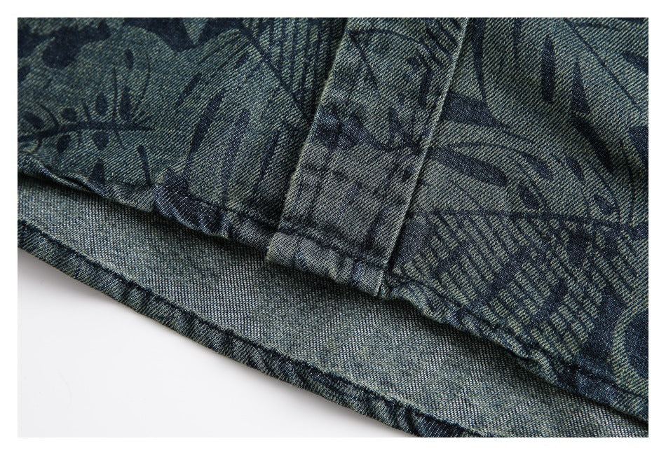 Close-up of a stitched garment hem and seam in blue-gray fabric with a dark abstract print.