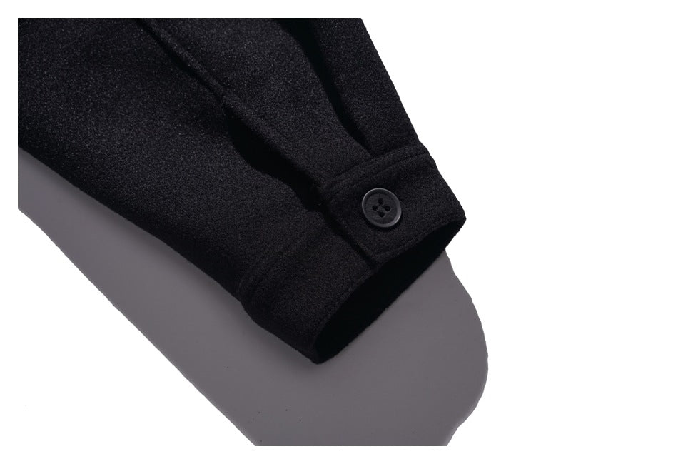 Close-up of a black sleeve cuff with a single black button and stitched seams.