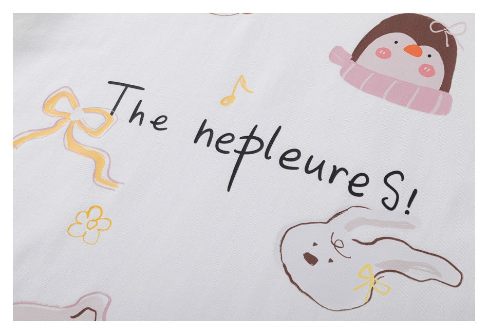 Close-up of the T-shirt’s printed lettering, pastel bow, flower, scarf-wearing character and reclining rabbit.