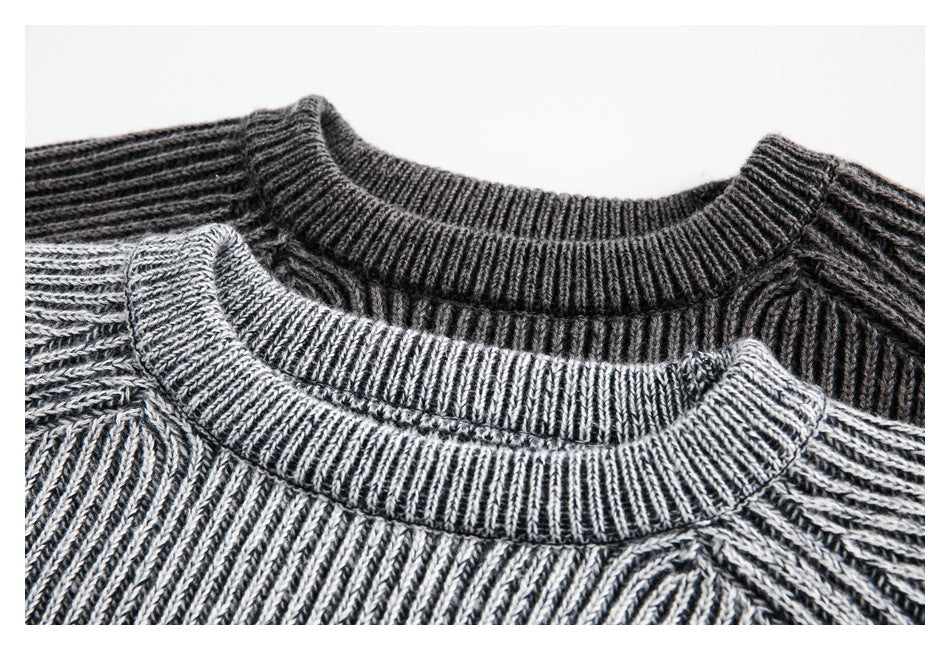 Close-up of ribbed crewneck collars on light gray and charcoal marled sweaters.