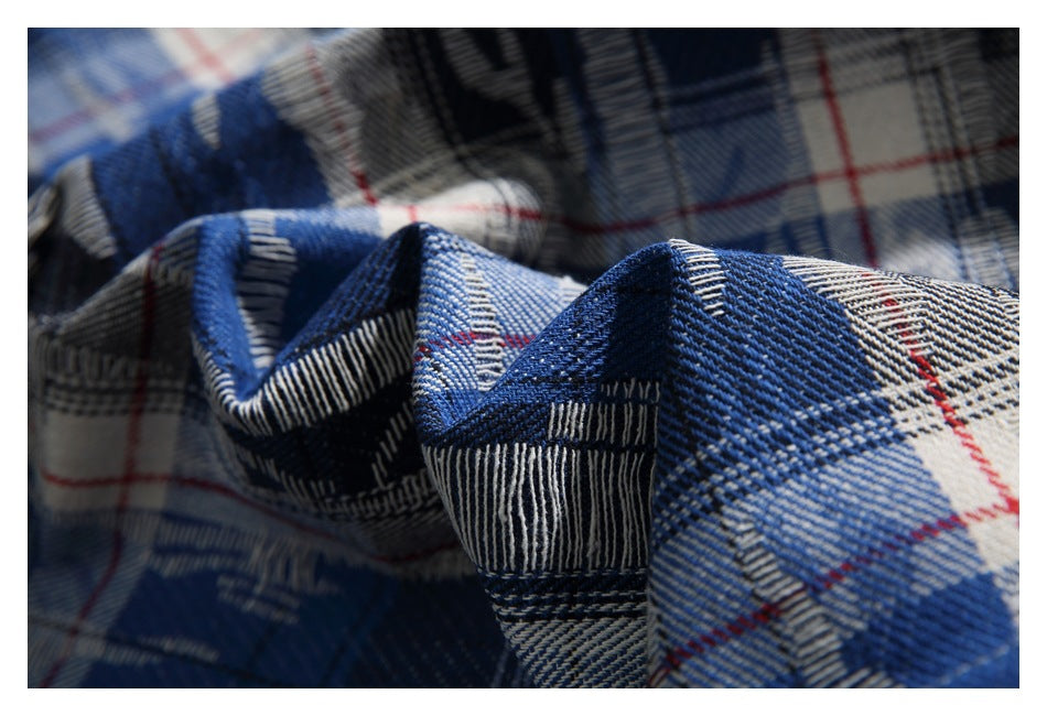 Close-up of blue, white, gray, and red plaid fabric gathered into folds.