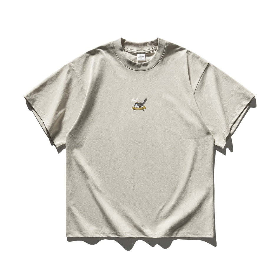 Apricot short-sleeve crew-neck T-shirt with a small cat-on-skateboard graphic on the chest, flat lay front view