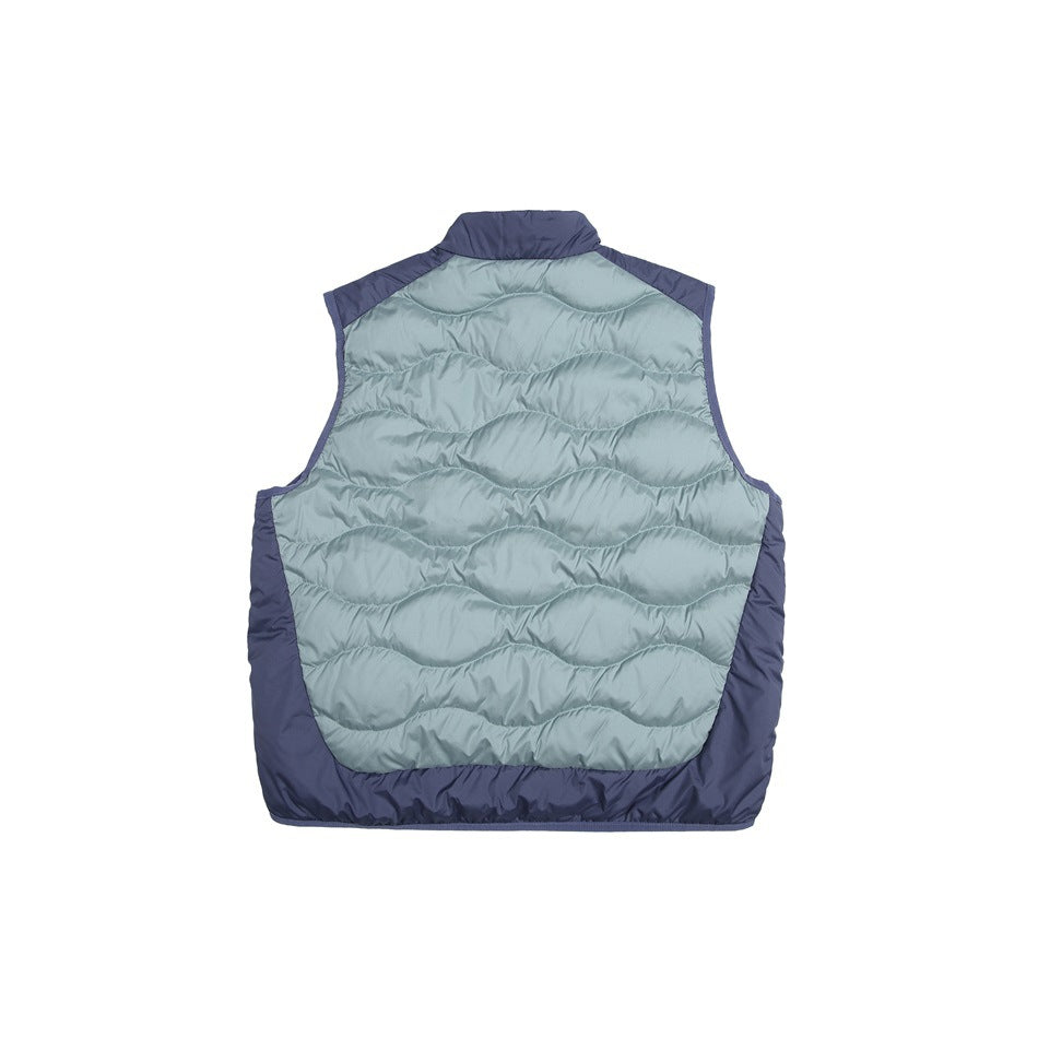 Back of a sleeveless quilted vest with a pale blue-gray wavy-stitched panel and navy sides and trim.