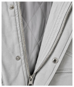Close-up of the light gray jacket's zipper, snap placket, and quilted inner lining.