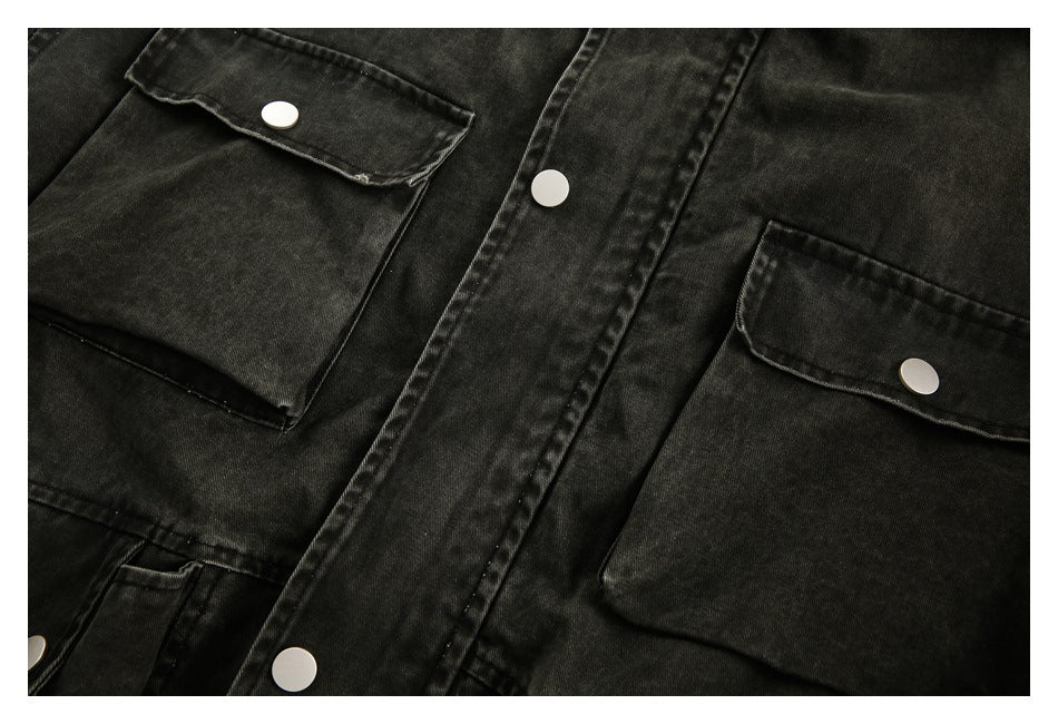 Close-up of the dark washed jacket's front, showing snap-fastened flap pockets and the center placket.