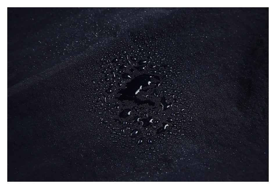 Water droplets beading on the dark navy jacket fabric.