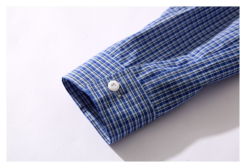Close-up of a blue plaid shirt cuff with a white button.