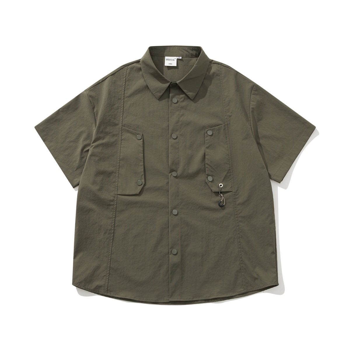 Army green short-sleeve shirt flat lay with snap front, two flap chest pockets and a small hook charm