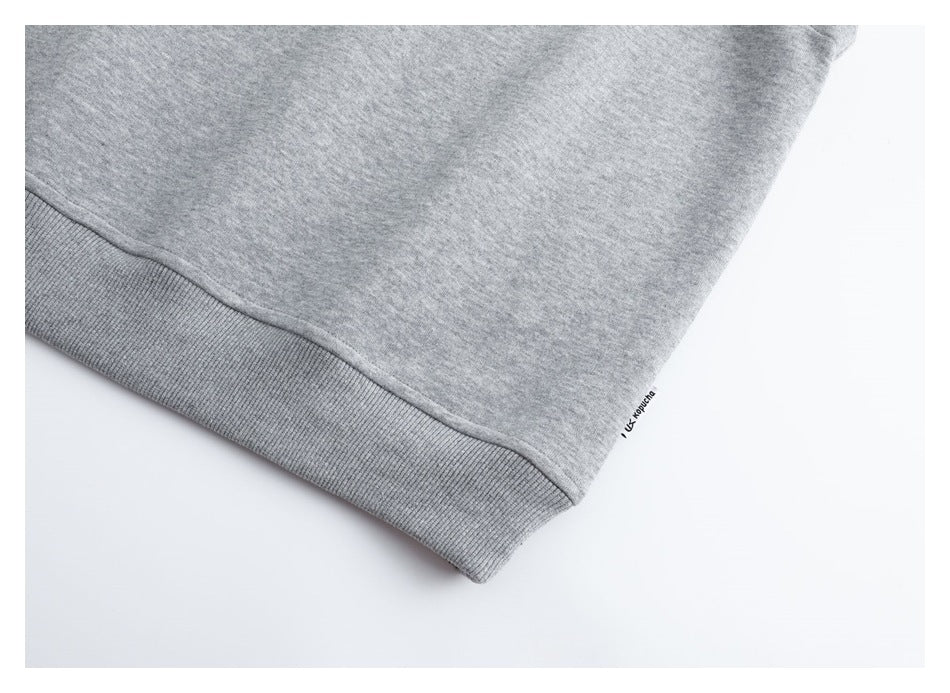 Close-up of the vest's ribbed hem and small sewn side label.