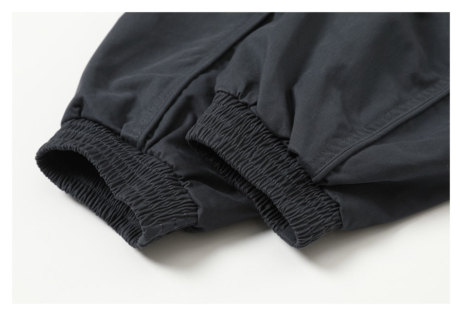 Close-up of two elasticized cuffs on dark charcoal garment sleeves.