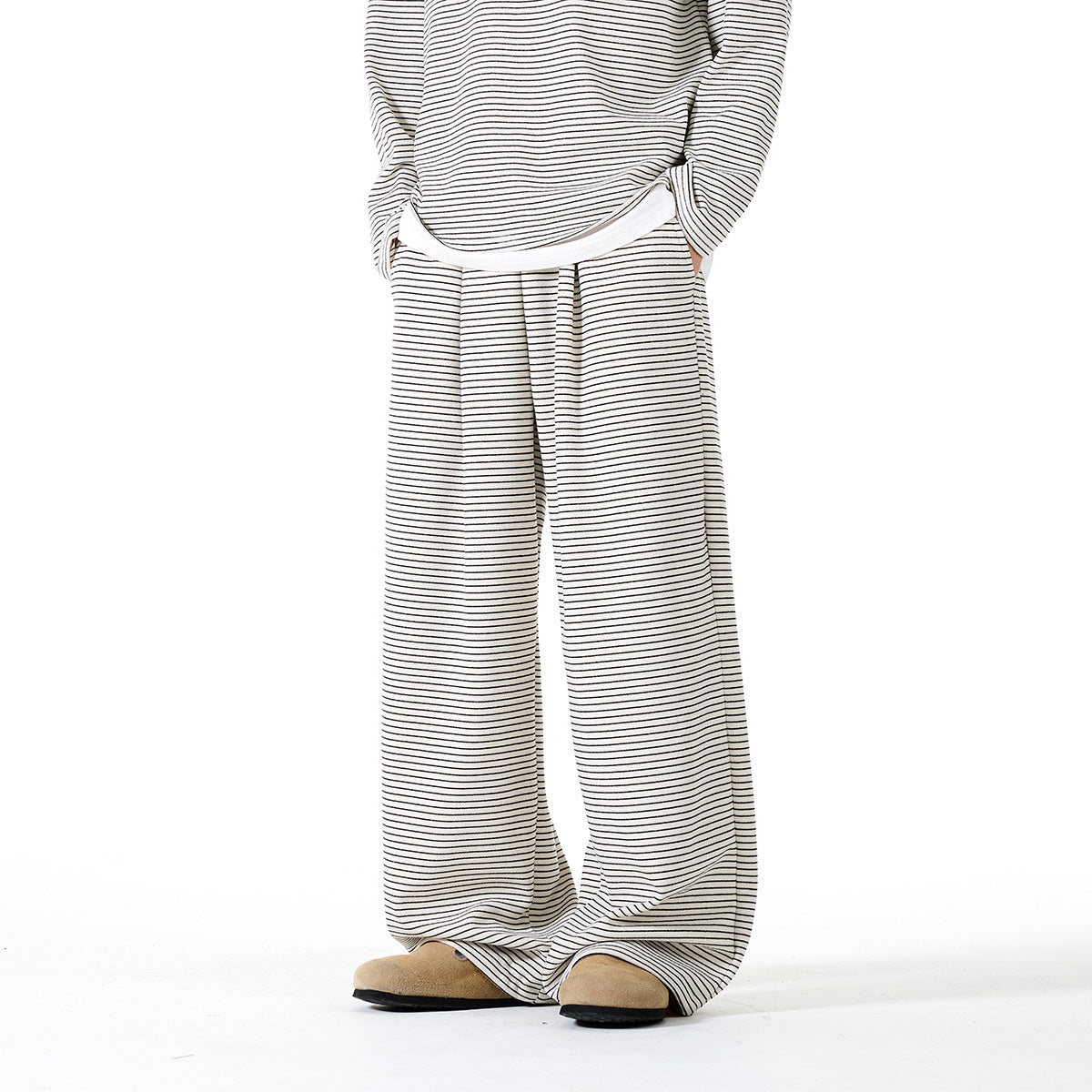 Front view of a model wearing cream wide-leg pants with thin black horizontal stripes and matching top.