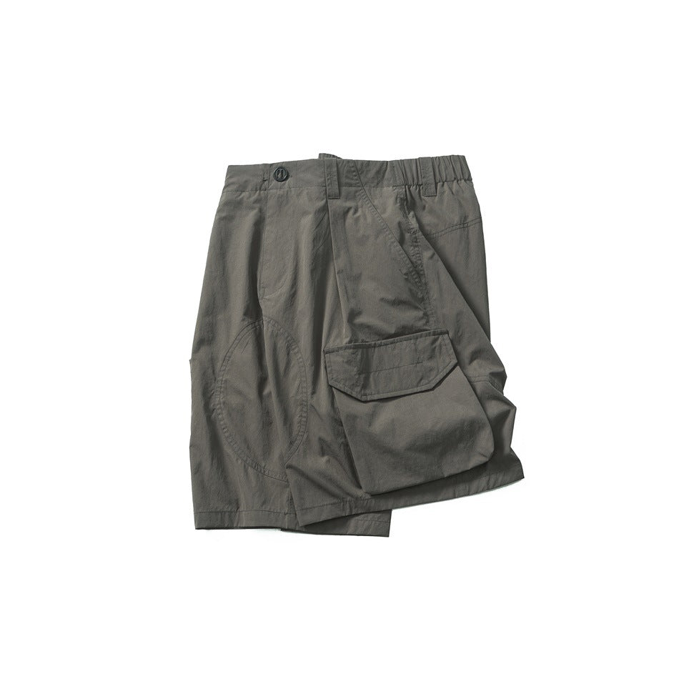 Flat lay of dark gray cargo shorts with an elastic waist, button closure, and large flap pocket.