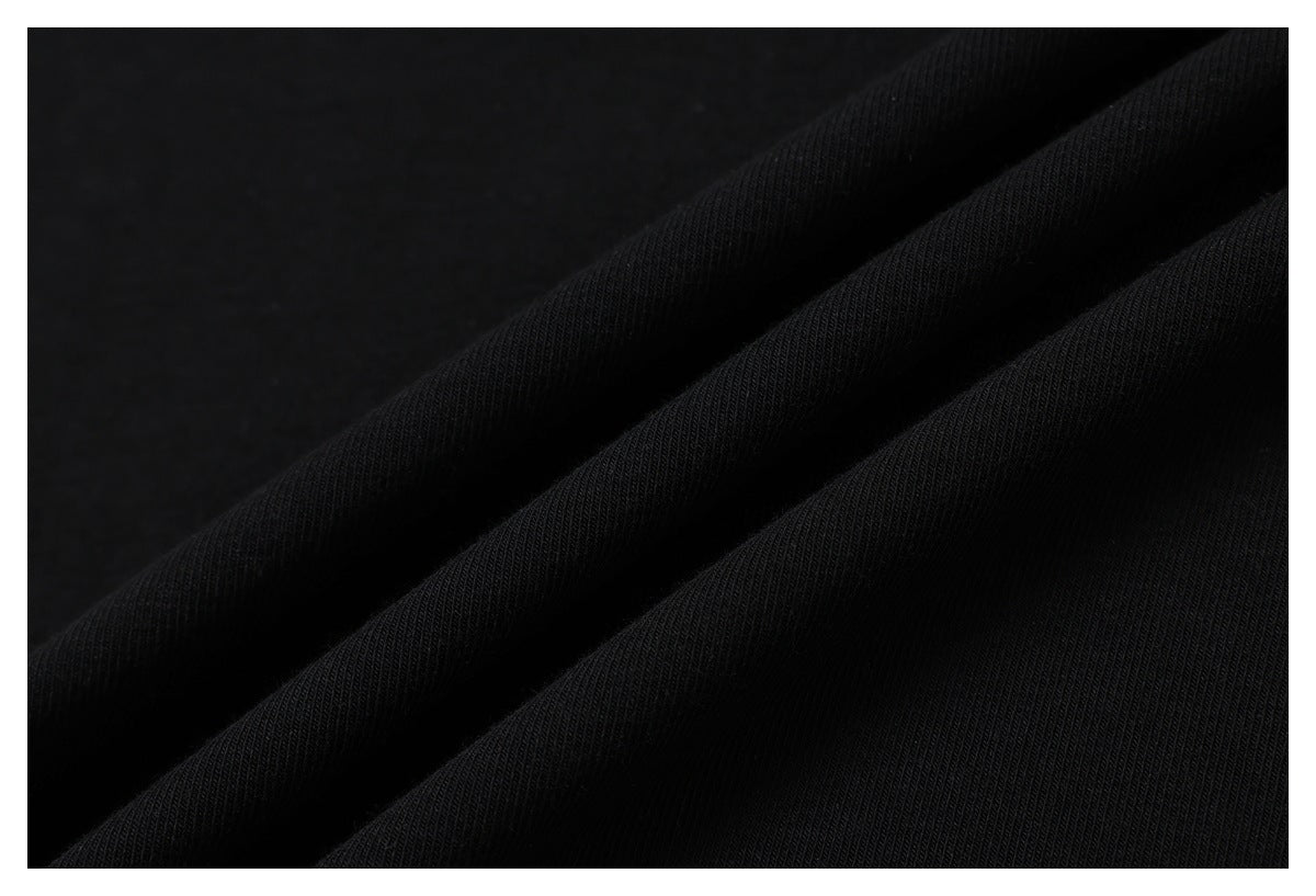 Macro view of black T-shirt fabric arranged in soft folds, showing its knit texture.