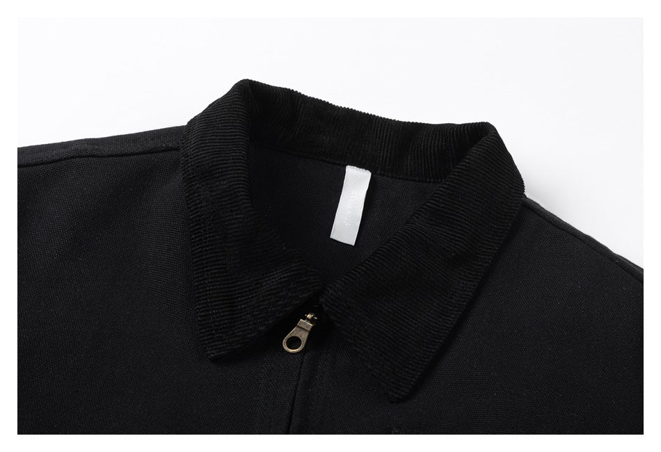 Close-up of the black jacket's ribbed collar, neckline, zipper pull, and blank white neck label.