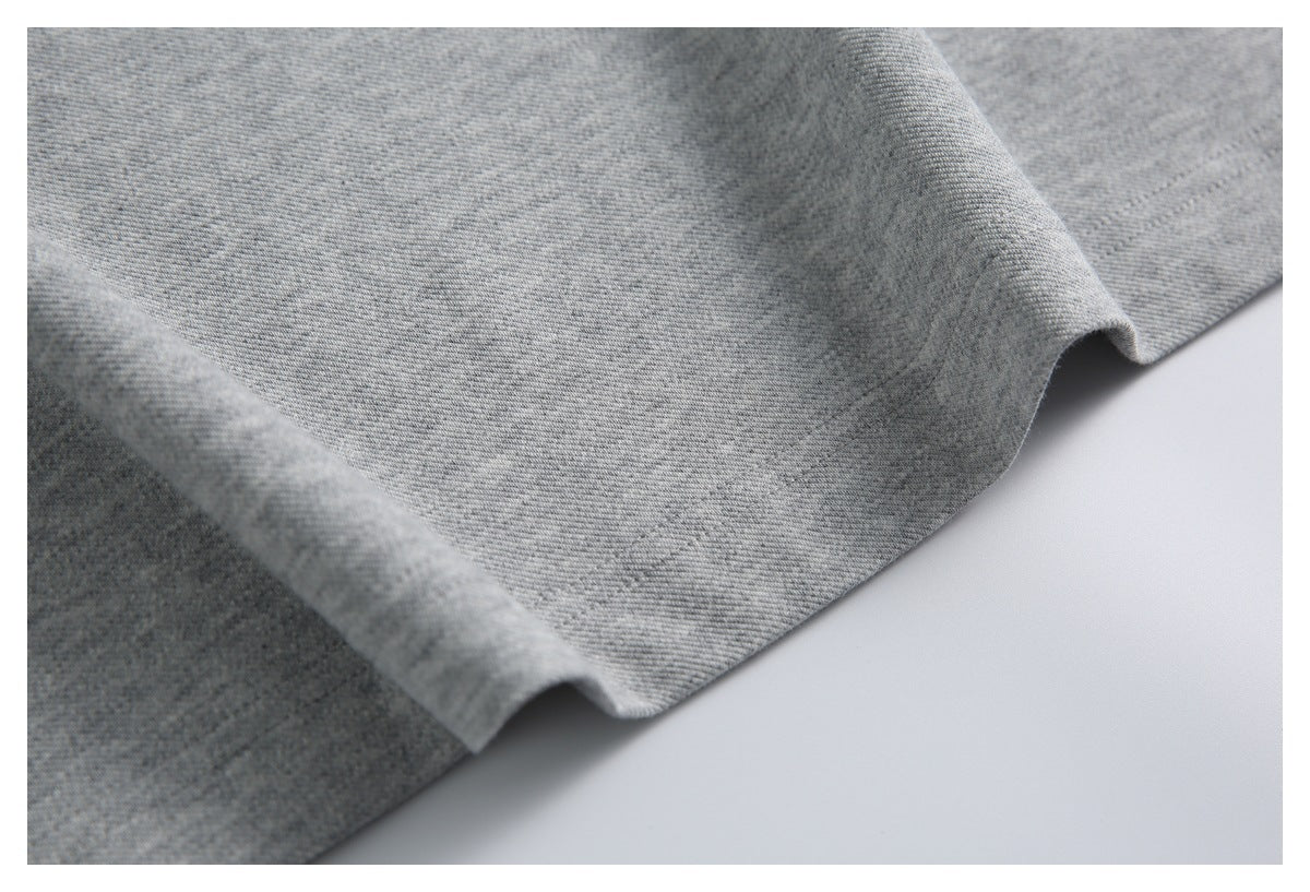 Close-up of the gray garment's stitched hem and softly folded edge.