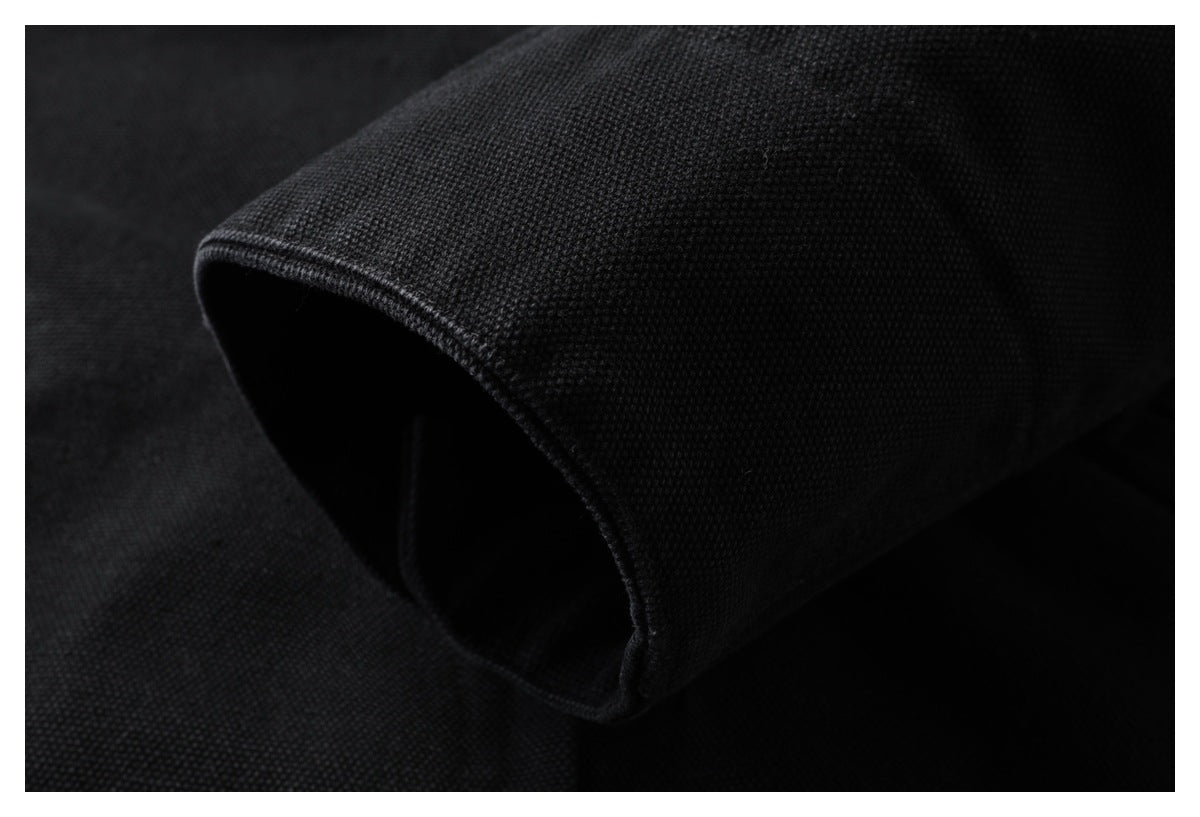 Close-up of black textured fabric folded to show a finished curved edge.