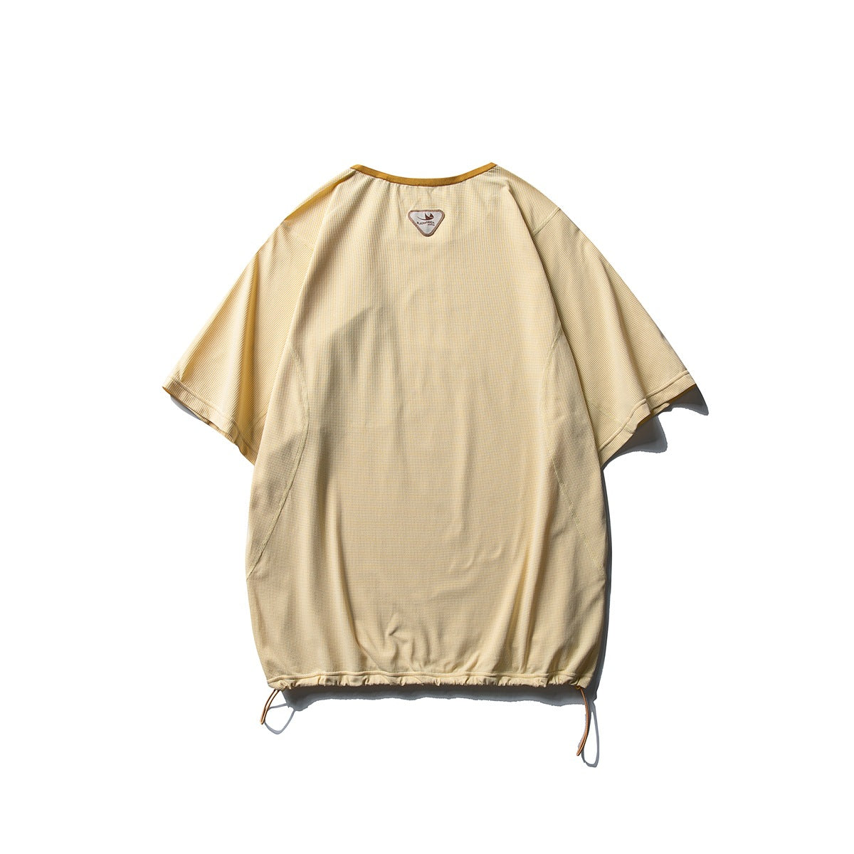 Back of a loose pale yellow short-sleeve top with curved seams, a small neck label and drawcords at the hem.
