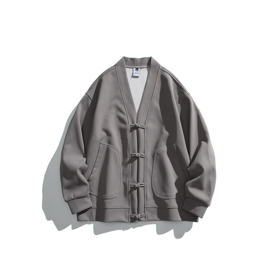 Gray waffle-textured V-neck cardigan jacket with frog-button front and two round patch pockets, flat lay