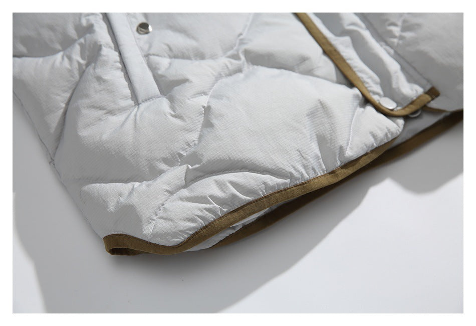 Close-up of the quilted jacket hem with brown edging and a snap placket.