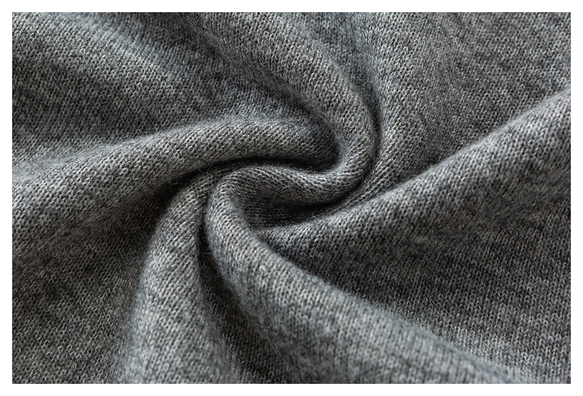 Close-up of heather gray knit fabric gathered into folds, showing its stitch texture.