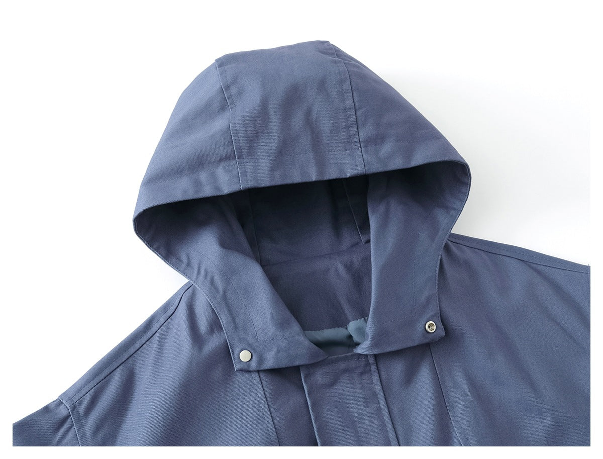 Close-up of a slate-blue jacket’s hood, snap fasteners, and front placket.