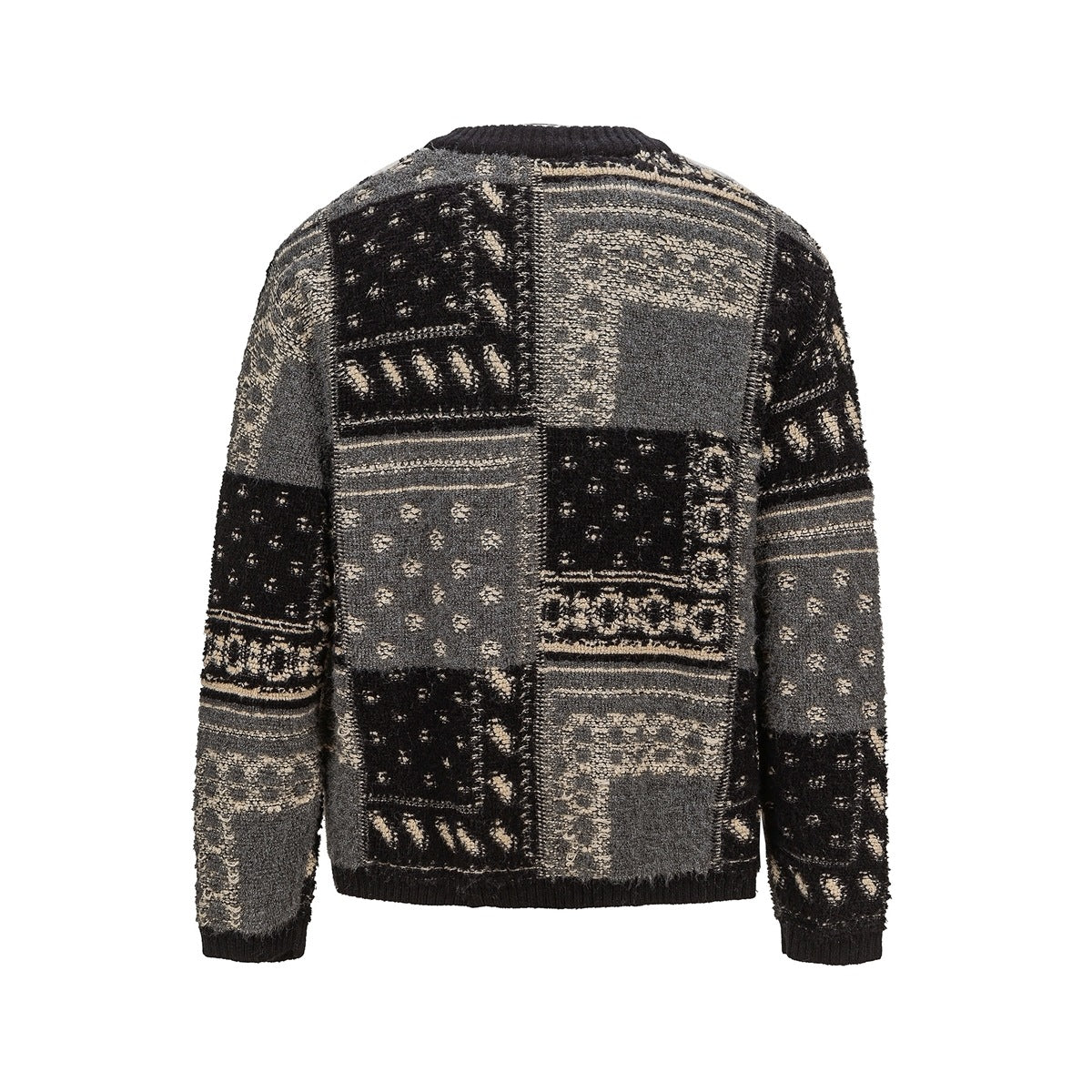 Back view of a long-sleeved sweater with a black, gray, and cream patchwork-style knit pattern and black ribbed trim.