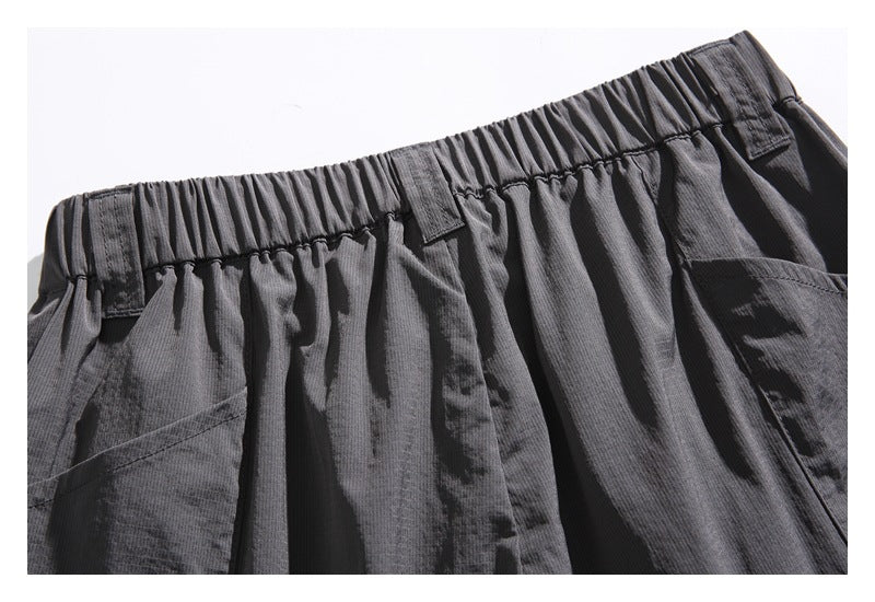 Close view of the back of charcoal shorts with an elastic waistband and large pockets.